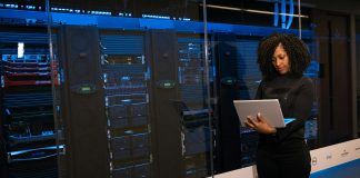 software engineer standing beside server racks