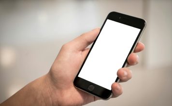 selective focus photography of person holding iphone displaying white screen