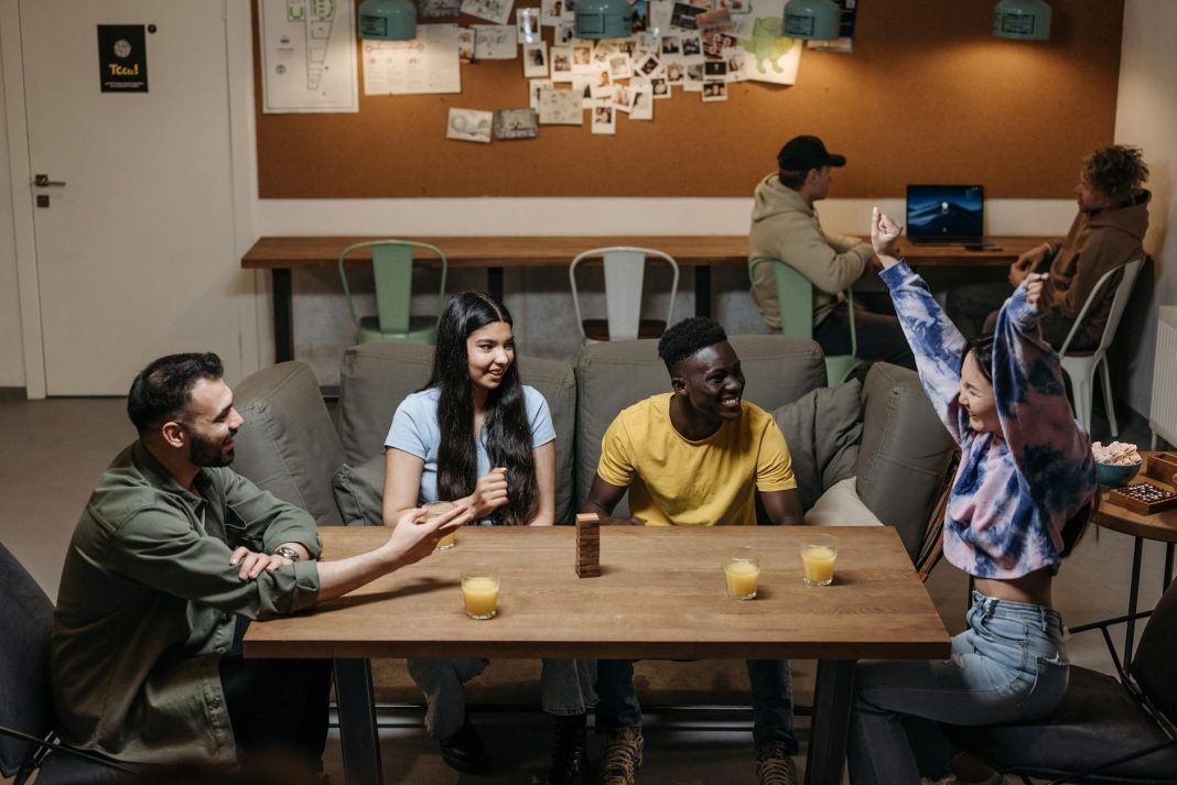 smiling friends sitting by table