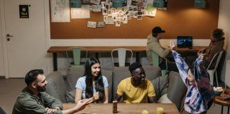 smiling friends sitting by table