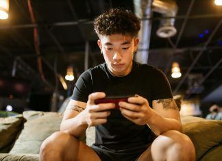 Bagaimana Tabiat Kasino Rakyat Malaysia Berbanding Dunia? man in black crew neck t shirt playing mobile game