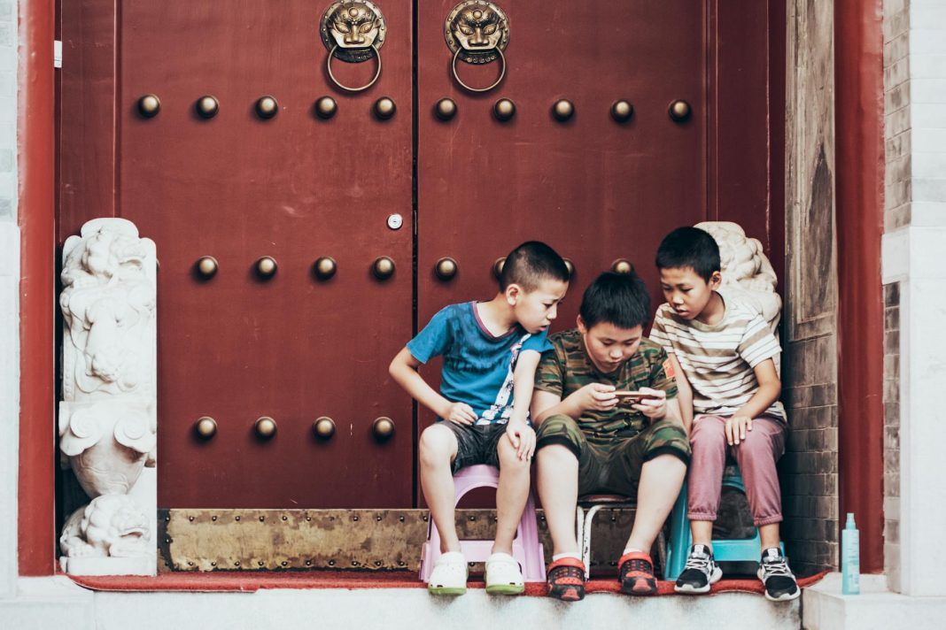 three boys sitting beside door