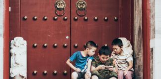 three boys sitting beside door