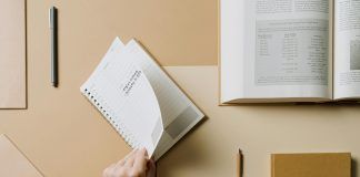person turning the page of a spiral notebook