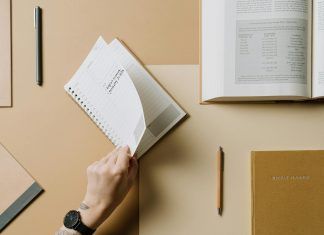 person turning the page of a spiral notebook