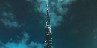 people standing near high rise building during night time