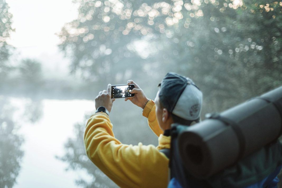 pexels-photo-5048613 person in yellow jacket taking photo in the forest