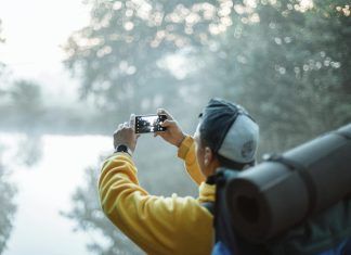 How Much Flagship Smartphones Are Expected to Cost in 2026 person in yellow jacket taking photo in the forest