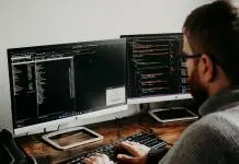 man working on computers coding