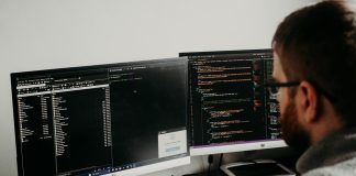 man working on computers coding