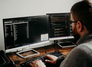 man working on computers coding