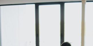 man in black shirt sits behind desk with computers