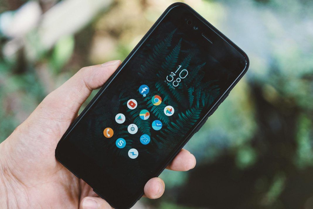 person holding black android smartphone with black case