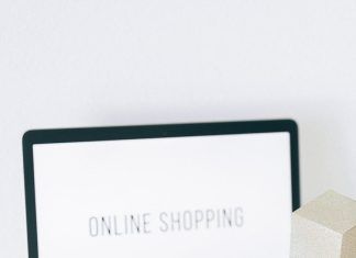 How to Shop Globally for Less With the Ultimate Shipping Hack a miniature shopping cart and smartphone on macbook laptop