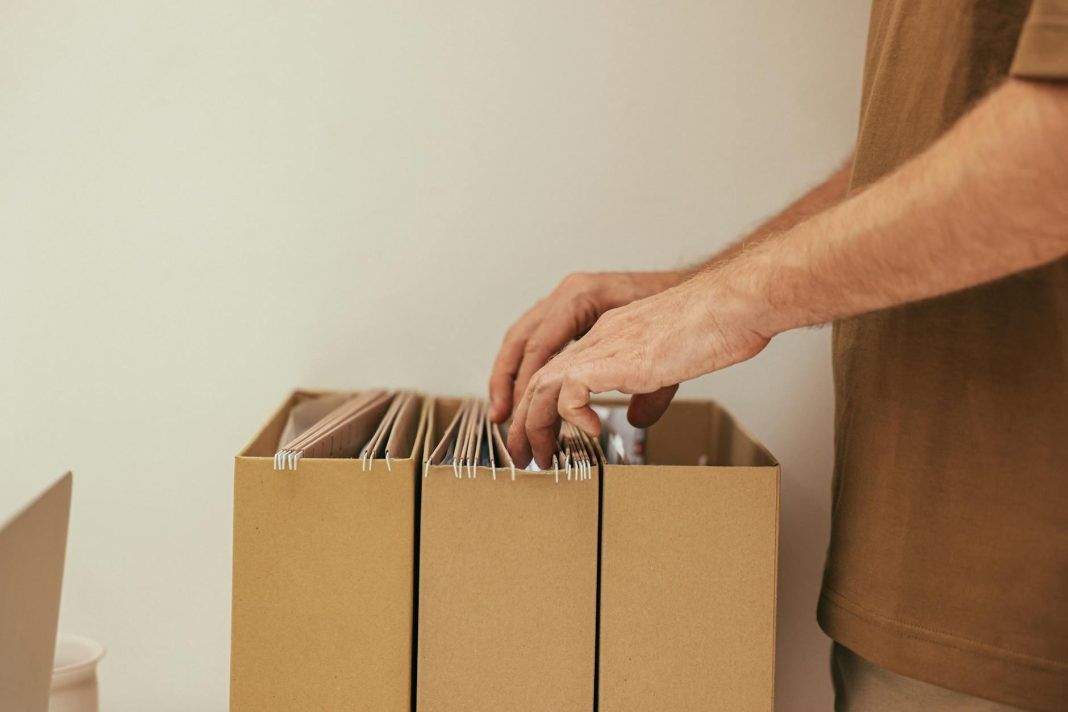 a person looking through a cardboard file organizer