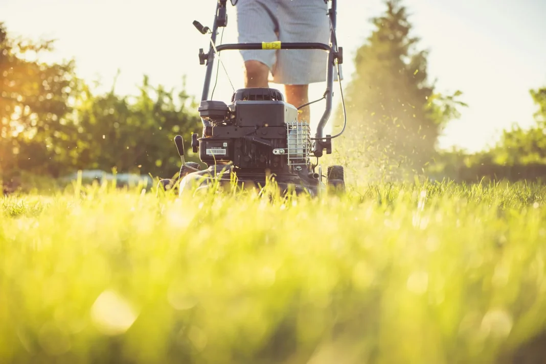 a person cutting grass with a lawn mower