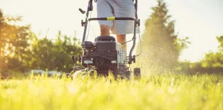 a person cutting grass with a lawn mower