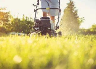 a person cutting grass with a lawn mower