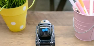 black miniature robot toy on wooden surface