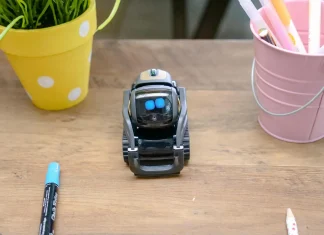 black miniature robot toy on wooden surface