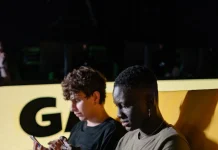 Live Dealer Games Explained: What New Players Should Know Before Joining a Table men sitting on the couch while playing on their mobile phone