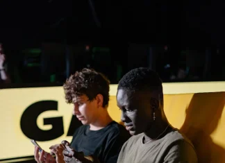 men sitting on the couch while playing on their mobile phone